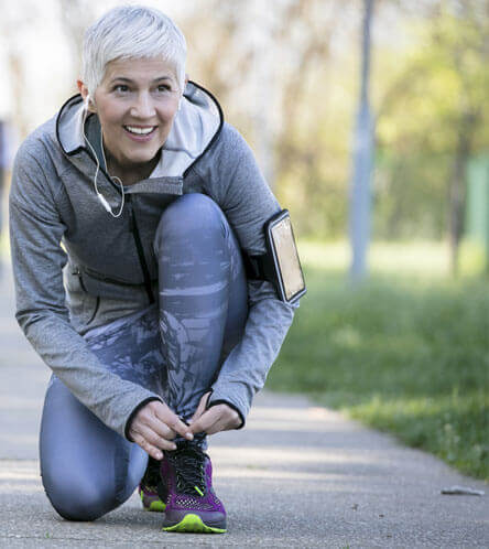 woman out for a run tying her shoes